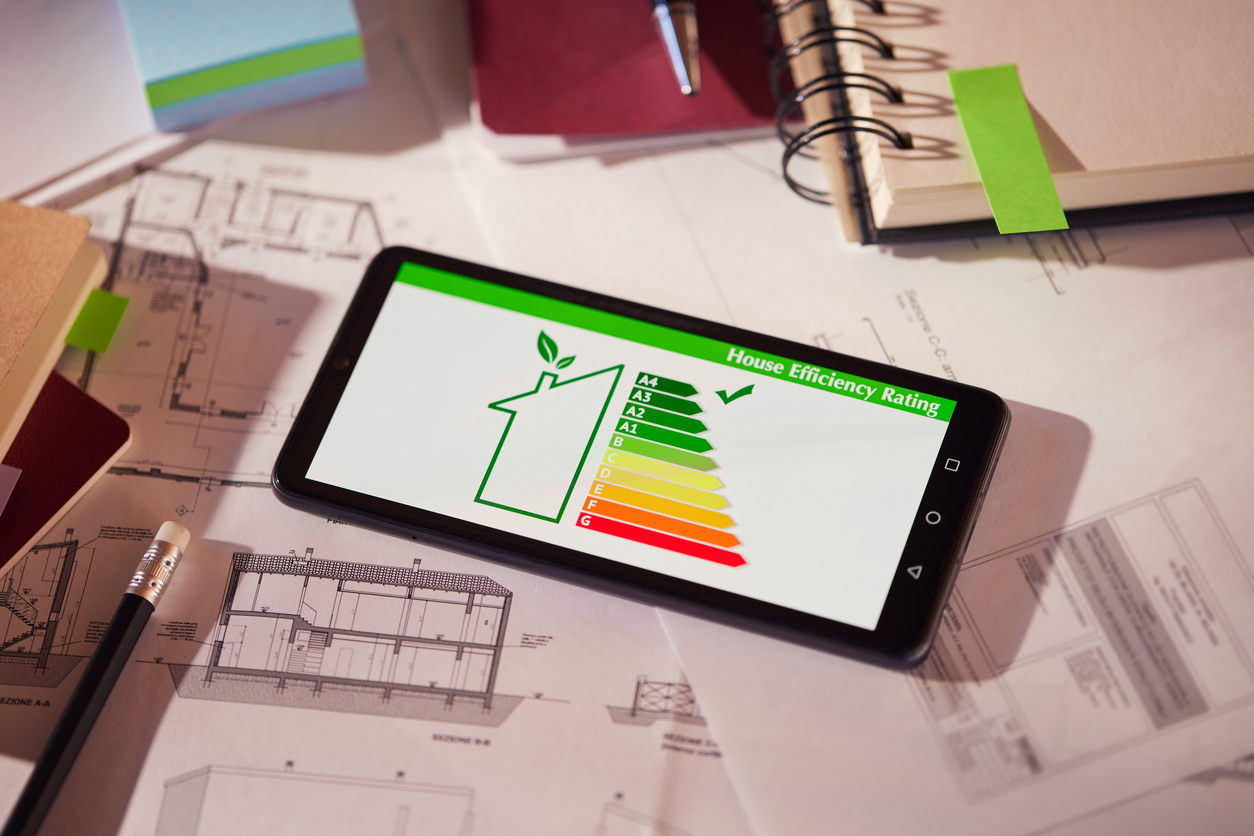 Energy efficiency mobile app on screen. Closeup of detail of house efficiency rating on mobile phone. Home efficiency reading app on mobile phone kept on desk. Benefici dell'isolamento termico per l'efficienza energetica